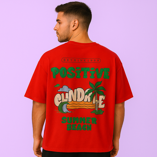 Model wearing a red oversized drop shoulder t-shirt with summer beach graphic on the back.